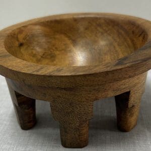Wooden bowl with four short legs.