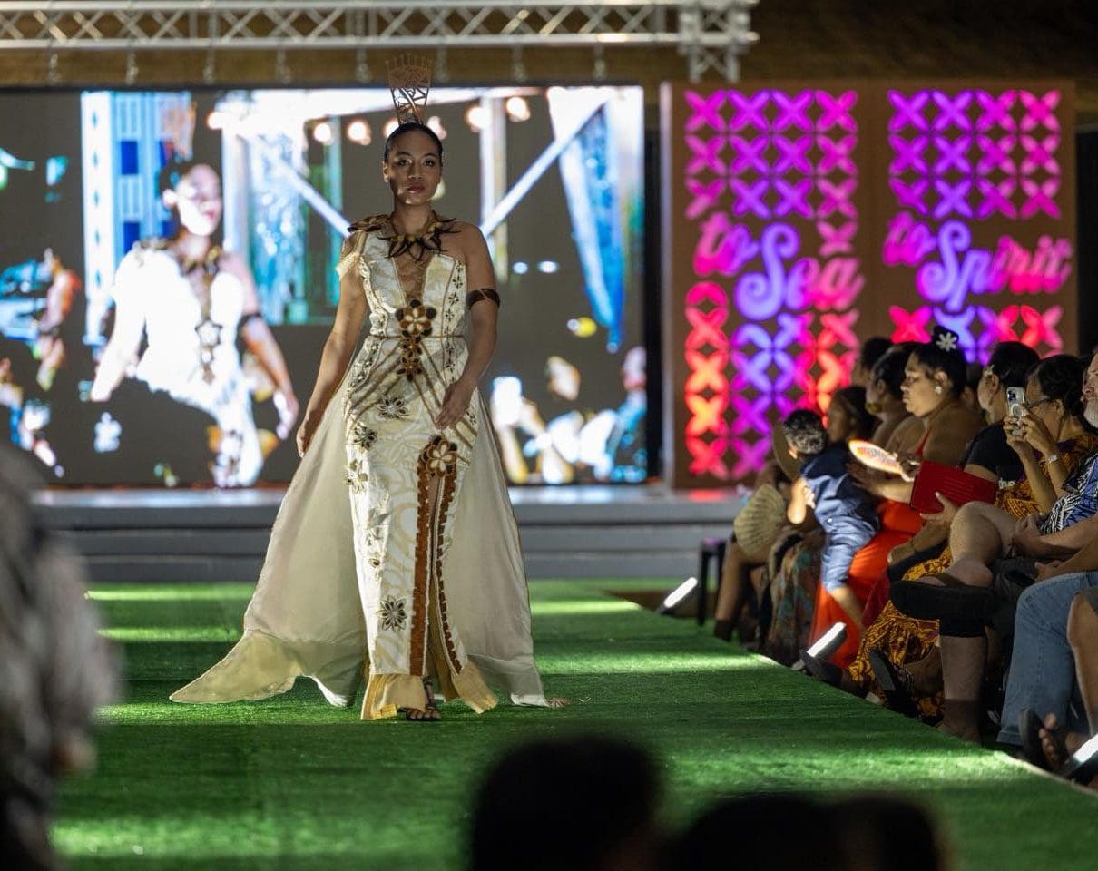 Model walking runway in elegant traditional dress.