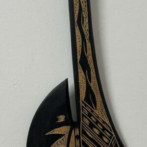 Decorative carved wooden paddle with geometric patterns
