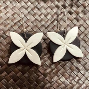 Round black earrings with white four-petal flowers