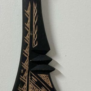Carved black wooden paddle with woven handle