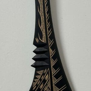 Black carved wooden paddle with rope handle