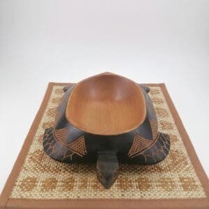 Carved wooden turtle bowl on woven mat